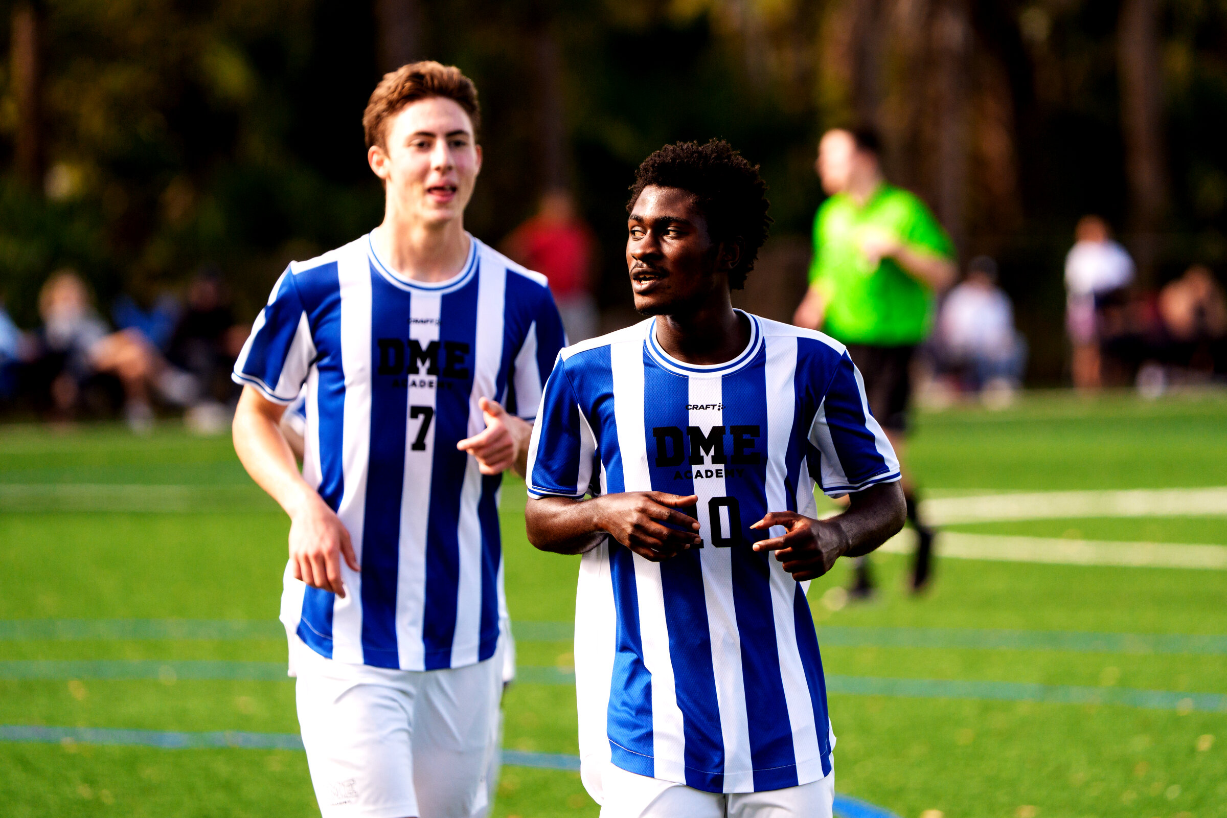 Two soccer players running in stride during training at DME Academy